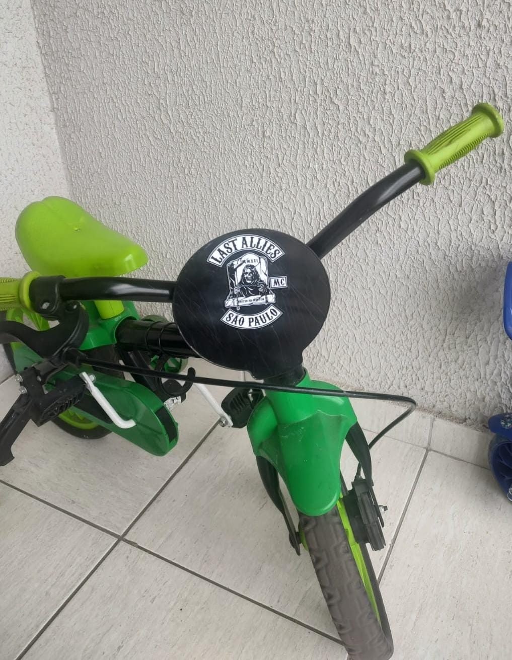 A bicicleta verde do Thomas, com a placa do Last Allies MC no guidão